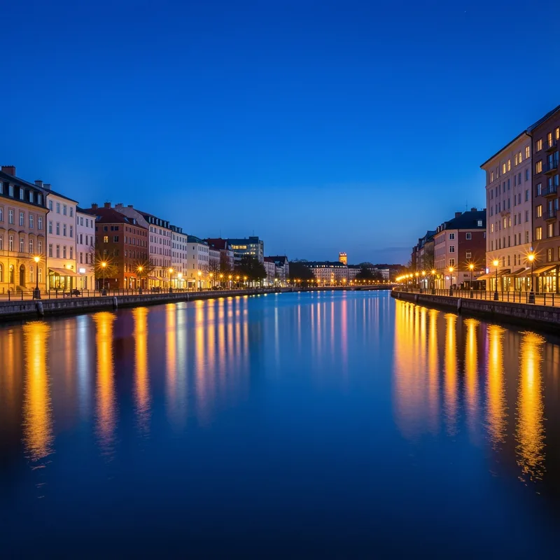 Quai urbain à l&rsquo;heure bleue, ciel bleu profond et lumières chaudes reflétées dans l&rsquo;eau